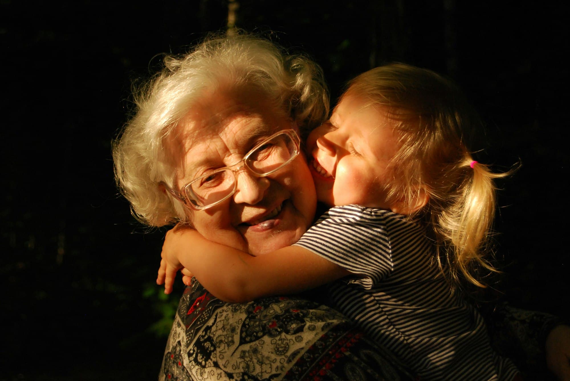 A grandmother hugging a young child